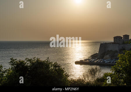 Beautiful sunset view on sea and Stadi Grad - old town of Ulcinj at twilight scene. Coast of Adriatic sea. Montenegro. Stock Photo