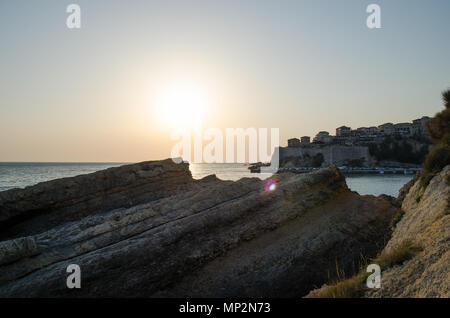 Beautiful sunset view on sea and Stadi Grad - old town of Ulcinj at twilight scene. Coast of Adriatic sea. Montenegro. Stock Photo