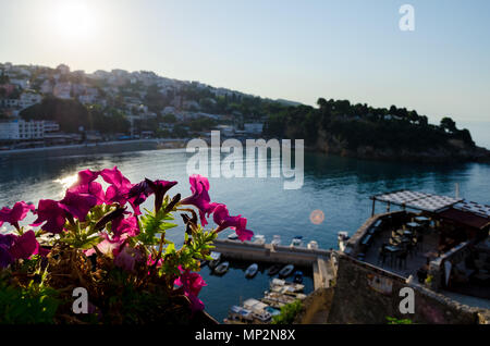 Small fishing boats marina with round pier. Wide angle shot with a city and central beach Mala Plaza on background. Ulcinj, Montenegro. Stock Photo