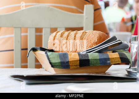 Close up of a bread sliced on a wooden basket, placed on a table of a traditional Greek tavern in Volos, Greece. Stock Photo