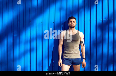 A man with a beard athlete runner in headphones. Stock Photo