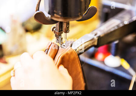 Stitching leather, leather stitching, sewing leather, leather sewing, repair, repairing leather, repairing, stitching machine, using sewing machine, Stock Photo