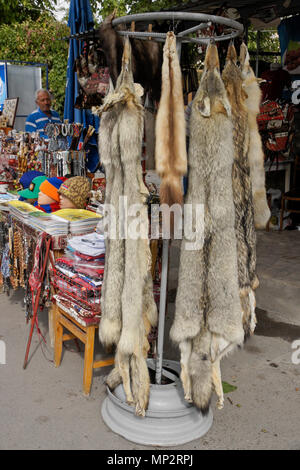 The pelts of wolves, foxes, and other wildlfe are among items on display in a souvenir shop at the entrance to Garni Temple, Garni, Armenia Stock Photo