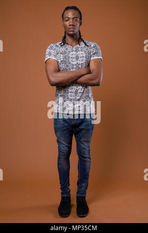 Young handsome African man against brown background Stock Photo