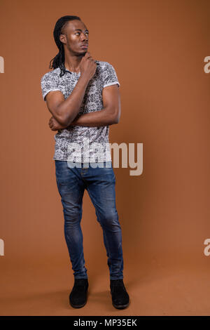 Young handsome African man against brown background Stock Photo