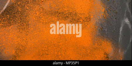 Grey plaster wall with orange graffiti spray paint shape Stock Photo