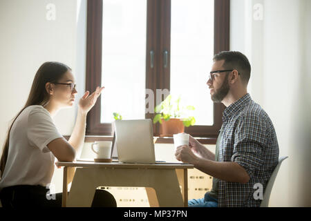 Concerned freelancers negotiating and working at laptops Stock Photo
