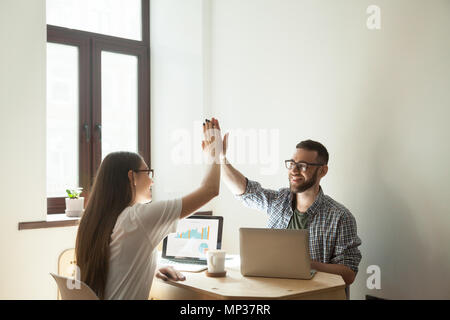 Freelance workers giving high five after successful project star Stock Photo