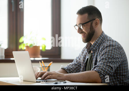 Happy male writing positive mail to client Stock Photo