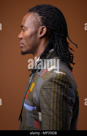 Young handsome African businessman against brown background Stock Photo