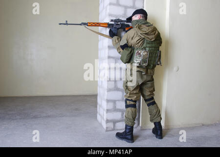 mercenary sniper with sniper rifle inside the building Stock Photo