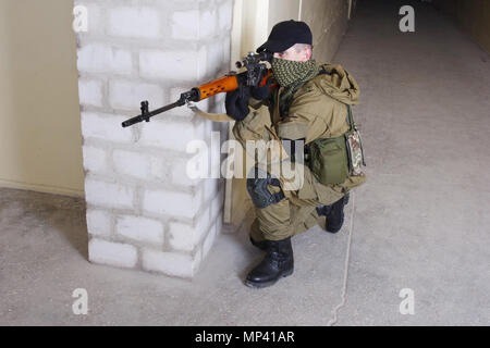 mercenary sniper with sniper rifle inside the building Stock Photo