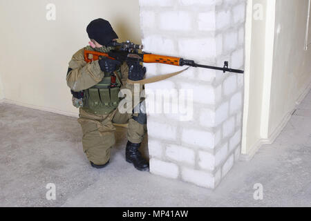 mercenary sniper with sniper rifle inside the building Stock Photo