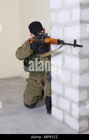 mercenary sniper with sniper rifle inside the building Stock Photo