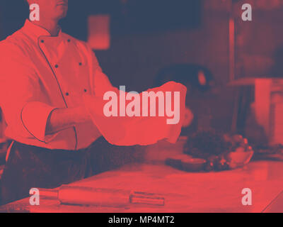Skilled chef preparing dough for pizza rolling with hands and throwing up Stock Photo