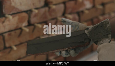 closeup worker applying concrete glue to brick cuts tile Stock Photo