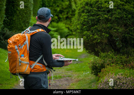 Hiker using map and compass for navigation Stock Photo
