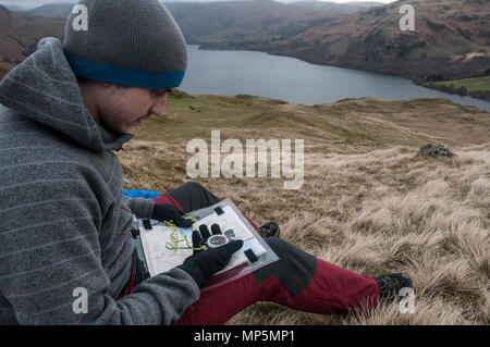 Walker using a compass and map to find way Stock Photo