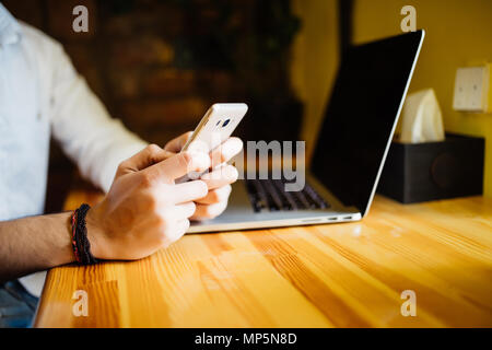 Concentrated handsome well-dressed male international student typing on laptop computer text of creative report for homework using information from we Stock Photo