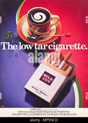 1980s original old vintage advertisement advertising Benson and Hedges Silk Cut filter tip low tar cigarettes with government health warning advert in English magazine circa 1980 Stock Photo