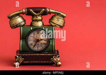 Creative alarm clock with vintage telephone  style on red background Stock Photo