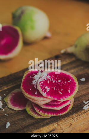 Watermelon Radishes Sliced, Sprinkled with Sea Salt on a wooden background Stock Photo