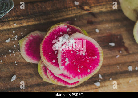 Watermelon Radishes Sliced, Sprinkled with Sea Salt on a wooden background Stock Photo