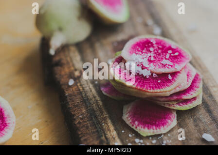 Watermelon Radishes Sliced, Sprinkled with Sea Salt on a wooden background Stock Photo