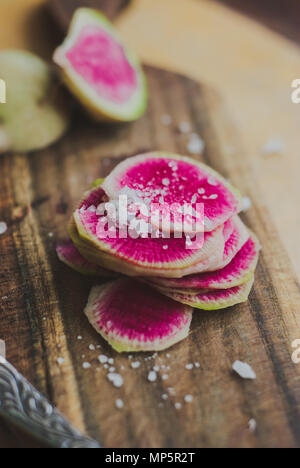 Watermelon Radishes Sliced, Sprinkled with Sea Salt on a wooden background Stock Photo