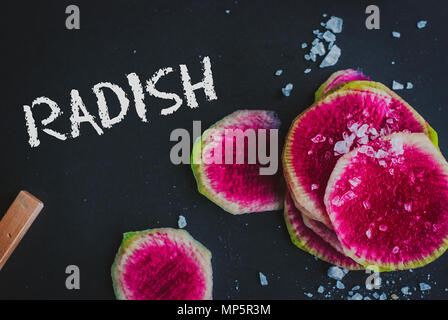 Watermelon Radishes Sliced, Sprinkled with Sea Salt on a black background Stock Photo