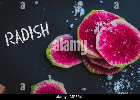 Watermelon Radishes Sliced, Sprinkled with Sea Salt on a black background Stock Photo