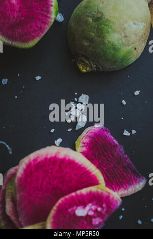 Watermelon Radishes Sliced, Sprinkled with Sea Salt on a black background Stock Photo