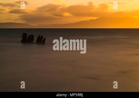 Old Shipwreck on the beach near Ardrossan looking towards the Isle of Arran, Scotland, UK Stock Photo