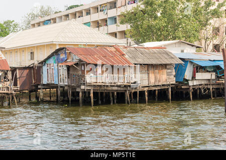 Rickety old wooden shanty buildings and homes on the side of the River Chao Phraya Bangkok Thailand Stock Photo