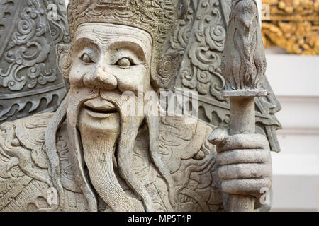 The face of a stone carving in the grounds of the Wat Pho (the Temple of the Reclining Buddha), or Wat Phra Chetuphon Bangkok Thailand Stock Photo