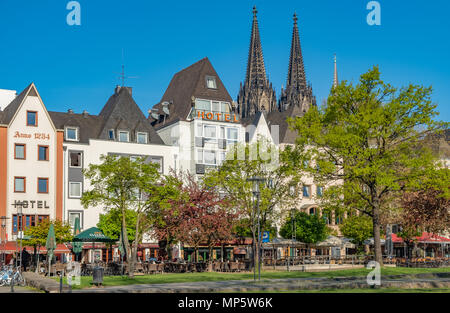 Strip of hotels and bars along the Rhine river catering mostly to visitors in Cologne Germany. Spires of the Colgne Cathedral can be seen in the backg Stock Photo