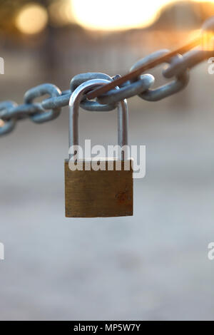 Closed padlock hanging from a thick chain Stock Photo