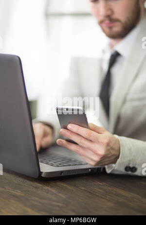 Office world, time brake. Businessman working at the wood table with new business project. Man touching screen modern mobile phone. Horizontal mockup. Flares, film effect Stock Photo