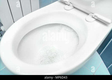 Water flushes the toilet. Stock Photo