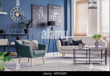 Navy blue living room interior with designer decor, black artwork and elegant comfortable sofa and armchair Stock Photo