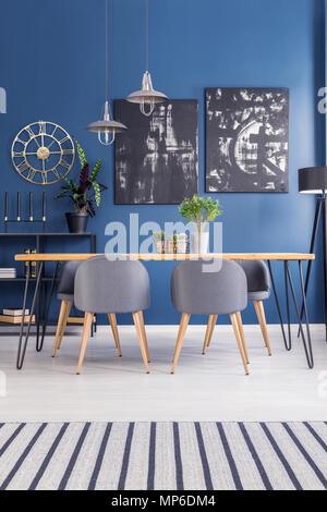 Modern dining set furniture in a vibrant open space interior with navy blue walls and stylish decor Stock Photo