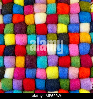 Close up full frame view of a vibrant multi coloured felt booble table mat Stock Photo