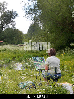 Cambridge, UK. 21st May 2018 An artist paints a scene in a meadow during the warm weather in Cambridge, UK. Credit: Jason Mitchell/Alamy Live News Stock Photo