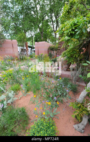 London, UK. 21st May 2018. The M&G Garden (designed by Sarah Price), one of the beautiful and elegant show gardens on display at the 2018 RHS Chelsea Flower Show which opened today in the 11-acre grounds of the Royal Hospital Chelsea, London, United Kingdom.  The garden is a romanticised haven set in a warm, sunny climate. It expands on a simple, timeless idea that three core elements - a wall, trees and seating - can create an intimate, sheltered and beautiful oasis of calm. Credit: Michael Preston/Alamy Live News Stock Photo