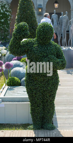 Royal Hospital Chelsea, London, UK. 21 May, 2018. Press day for the RHS Chelsea Flower Show 2018. Photo: Two large Topiary Hedgemen spring to life to surprise visitors to the A Place in The Garden tradestand. Credit: Malcolm Park/Alamy Live News. Stock Photo