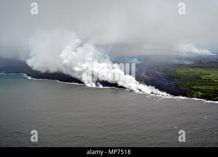 Hawaii, USA. 20th May 2018. Lava and poisonous sulfur dioxide plumes rise from fissure 20 as the molten magma reaches the ocean from the eruption of the Kilauea volcano May 20, 2018 in Pahoa, Hawaii. Hot lava entering the ocean creates a dense white plume called 'laze' (short for 'lava haze'). Laze is formed as hot lava boils seawater to dryness. Credit: Planetpix/Alamy Live News Stock Photo