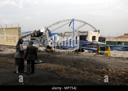 Sanaa, Yemen. 21st May, 2018. Yemeni men walk near wreckage of a petrol station after it was hit by airstrikes carried out by the Saudi-led coalition on the outskirts of Sanaa, Yemen, on May 21, 2018. Saudi Arabia has been leading an Arab military coalition against Houthis in support of the Yemeni exiled government over the last three years. Credit: Mohammed Mohammed/Xinhua/Alamy Live News Stock Photo