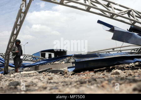 Sanaa, Yemen. 21st May, 2018. A man walks on wreckages of a petrol station after it was hit by airstrikes carried out by the Saudi-led coalition on the outskirts of Sanaa, Yemen, on May 21, 2018. Saudi Arabia has been leading an Arab military coalition against Houthis in support of the Yemeni exiled government over the last three years. Credit: Mohammed Mohammed/Xinhua/Alamy Live News Stock Photo