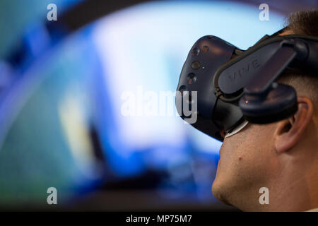Stuttgart, Germany. 15th May, 2018. 15 May 2018, Germany, Stuttgart: A man using a flight simulator with VR headset during the ITEC fair for military and weapons technology. Credit: Sebastian Gollnow/dpa/Alamy Live News Stock Photo