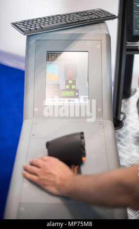 Stuttgart, Germany. 15th May, 2018. 15 May 2018, Germany, Stuttgart: A man using the Pilot Station flight simulator by Selt during the ITEC fair for military and weapons technology. Credit: Sebastian Gollnow/dpa/Alamy Live News Stock Photo